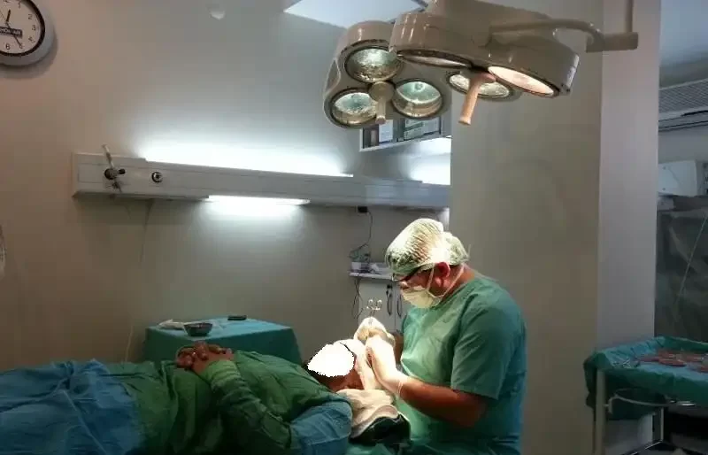 الدكتور محمد قوتشلو مع مريض يعانى من الصلع فى غرفة العمليات أثناء إجراء عملية زراعة الشعر فى المركز الأوروبى لزراعة الشعر
